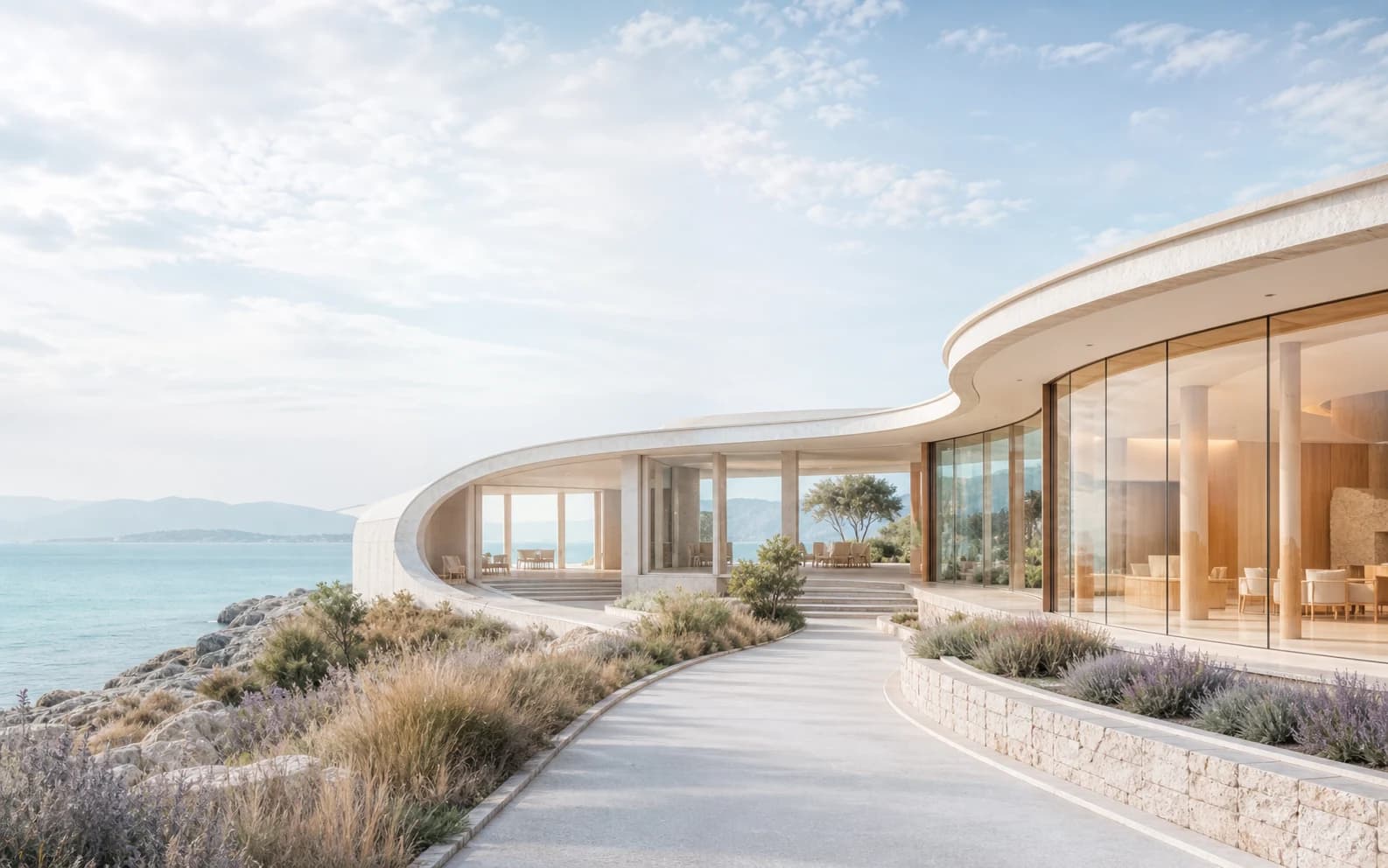 Bright curved white coastal pavilion overlooking a calm pale-aqua sea